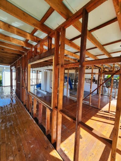 Timber wall frame exposed on the outside of a house with the fibro cladding removed