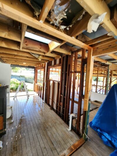 Timber frame and roof structure of a verandah exposed after wall sheeting was removed