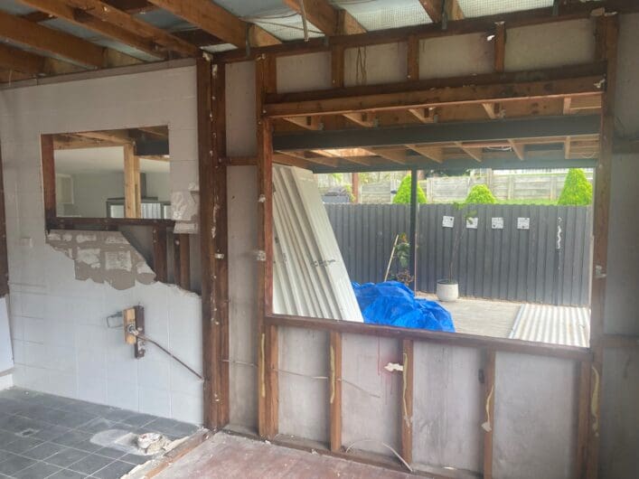 Interior wall framing exposed after fibro linings were taken out, looking towards a window