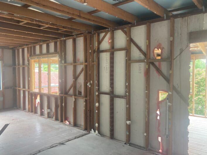 Stripped interior walls with the cut edges of the remaining sheeting sealed with pink PVA